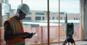 Trimble Ri robotic total station being controlled by female construction worker in hard hat